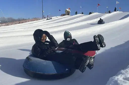 Nawal Hirsi, right, goes snow tubing with her family as part of a group promoting outdoors activities by Muslim women, at Elm Creek Park Reserve in Maple Grove, Minn., on Jan. 4, 2025. (AP Photo/Giovanna Dell'Orto)