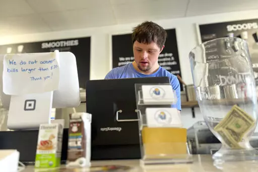 Patrick Chapman, 27, prepares for customers Thursday, March 2, 2023, at The Golden Scoop, an Overland Park, Kan., ice cream and coffee shop that employs workers with developmental disabilities, paying them more than minimum wage. But some disabled workers employed at so-called sheltered workshops are earning far less than minimum wage, an issue that has captured the attention of lawmakers in the state. Disability rights advocates say the practice is discriminatory and more than a dozen states ha