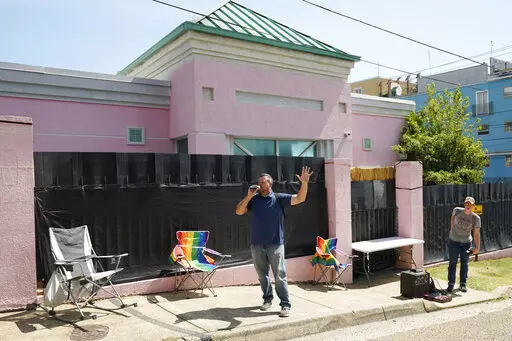 A couple of abortion opponents stand outside the Jackson Women's Health Organization clinic and call out to the patients inside the medical facility, encouraging them to not have an abortion, Jackson, Miss., Saturday, June 25, 2022. The clinic is the only facility that performs abortions in the state. However, on Friday, the U.S. Supreme Court overturned Roe v. Wade, ending constitutional protections for abortion. (AP Photo/Rogelio V. Solis)