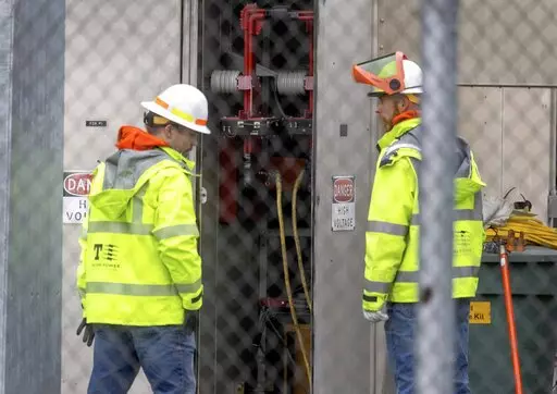 A Tacoma Power crew works at an electrical substation damaged by vandals early on Christmas morning, Sunday, Dec. 25, 2022 in Graham, Wa. (Ken Lambert/The Seattle Times via AP)