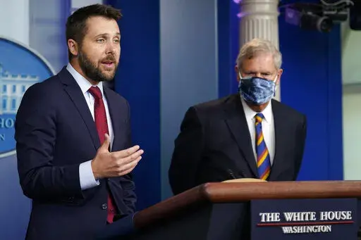 Director of the National Economic Council Brian Deese, left, speaks as Agriculture Secretary Tom Vilsack, right, listens during the daily briefing at the White House in Washington, Wednesday, Sept. 8, 2021. (AP Photo/Susan Walsh)