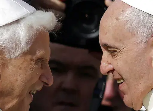 Pope Francis, right, greets Pope Emeritus Benedict XVI prior to the start of a meeting with elderly faithful in St. Peter's Square at the Vatican, on Sept. 28, 2014. Emeritus Pope Benedict XVI turned 95 this past weekend, a significant milestone on its own but even more given he has now been a retired pope longer than he was a reigning one.  To mark the occasion, a new book published Thursday, April 21, 2022 sets out to examine the current state of Vatican affairs not so much through the lens of