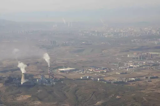 Smoke and steam rise from towers at the coal-fired Urumqi Thermal Power Plant as seen from a plane in Urumqi in western China's Xinjiang Uyghur Autonomous Region on April 21, 2021. China is promoting coal-fired power as the ruling Communist Party tries to revive a sluggish economy, prompting warnings that Beijing is setting back efforts to cut climate-changing carbon emissions from the biggest global source. (AP Photo/Mark Schiefelbein, File)