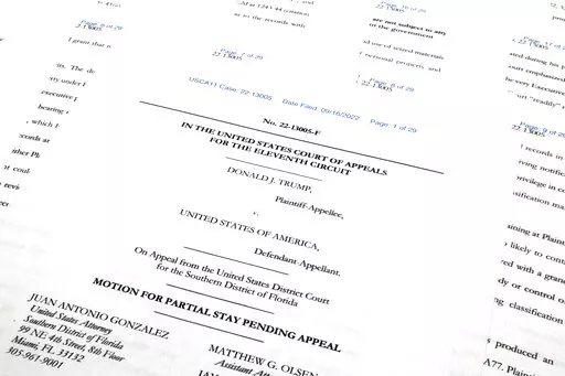 Pages from the Justice Department's motion to the 11th Circuit U.S. Court of Appeals in Atlanta are photographed Friday, Sept. 16, 2022. The Justice Department asked the federal appeals court to lift a judge's order that temporarily barred it from reviewing a batch of classified documents seized during an FBI search of former President Donald Trump's Florida home last month. (AP Photo/Jon Elswick)