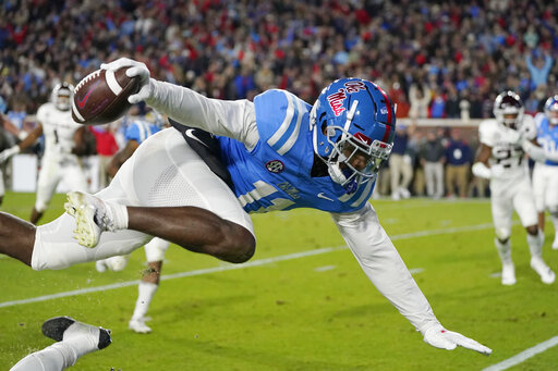 Mississippi wide receiver Dontario Drummond (11) is knocked into the air by a Texas A&M defender as he catches a short pass during the first half of an NCAA college football game, Saturday, Nov. 13, 2021, in Oxford, Miss. (AP Photo/Rogelio V. Solis)