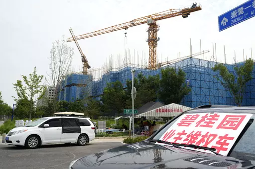 A car with a sign that reads, "Country Garden homeowners rights protections car," is parked near homeowners camping outside the Country Garden One World City project under construction on the outskirts of Beijing, Thursday, Aug. 17, 2023. China's government is trying to reassure jittery homebuyers after the major real estate developer missed a payment on its multibillion-dollar debt, reviving fears about the industry's shaky finances and their impact on the struggling Chinese economy. (AP Photo/