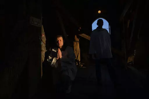 Retired policeman, Volodymyr Ilnytskyi, 55, prays before ringing the bell of the Latin Cathedral in Lviv, western Ukraine, Thursday, March 24, 2022. (AP Photo/Nariman El-Mofty)