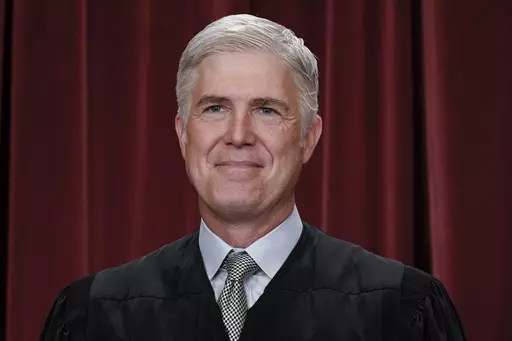 Associate Justice Neil Gorsuch joins other members of the Supreme Court as they pose for a new group portrait, at the Supreme Court building in Washington, Friday, Oct. 7, 2022. Gorsuch called emergency measures taken during the COVID-19 crisis that killed more than 1 million Americans perhaps “the greatest intrusions on civil liberties in the peacetime history of this country.” The 55-year-old conservative justice pointed to orders closing schools, restricting church services, mandating vac