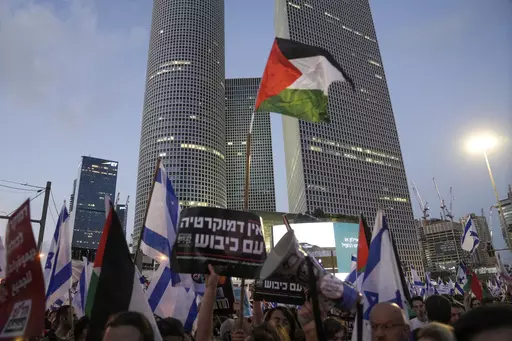 Demonstrators wave the Israeli and Palestinian flags during a protest against plans by Prime Minister Benjamin Netanyahu's government to overhaul the judicial system, in Tel Aviv, Israel, Saturday, July 22, 2023. Israel is being rocked by a wave of mass protests calling to uphold the country’s democracy. But the cries for democracy lack any clear message of opposition to Israel’s rule over millions of Palestinians, exposing a contradiction that has been coursing through the demonstrations. (