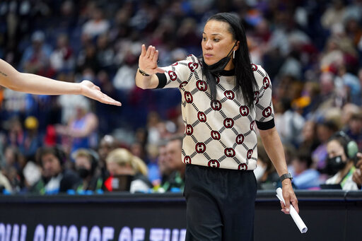 South Carolina head coach Dawn Staley congratulates a player during the second half of an NCAA college basketball semifinal round game against Mississippi at the women's Southeastern Conference tournament Saturday, March 5, 2022, in Nashville, Tenn. South Carolina won 61-51. (AP Photo/Mark Humphrey)