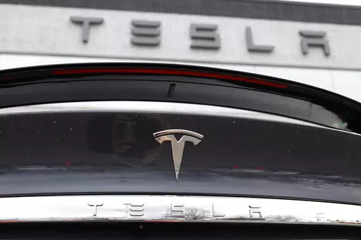 In this April 26, 2020 photo, the company logo shines off the rear deck of an unsold 2020 Model X at a Tesla dealership in Littleton, Colo. Tesla’s sales from April through June 2022 fell to their lowest quarterly level since last fall as supply chain issues and pandemic restrictions in China hobbled production of its electric vehicles. (AP Photo/David Zalubowski, File)