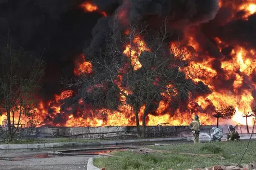 Donetsk People Republic Emergency Situations Ministry firefighters work at the site of fire at the oil depot after missiles struck the facility in an area controlled by Russian-backed separatist forces in Makiivka, 15 km (94 miles) east of Donetsk, eastern Ukraine, Wednesday, May 4, 2022. The representative office of the Donetsk People's Republic in the Joint Center for Control and Coordination of the ceasefire regime (JCCC) said on Wednesday that the city of Makiivka was shelled and, according 
