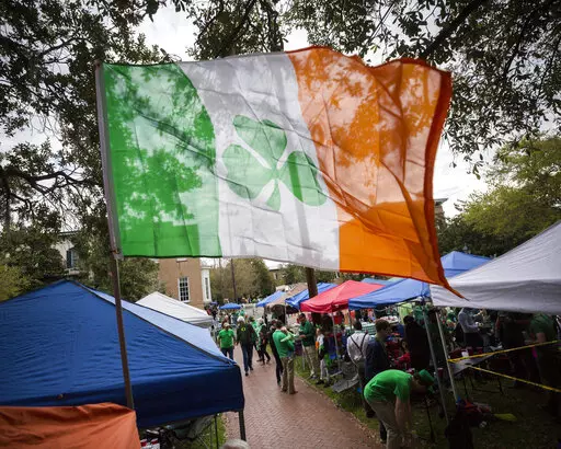 Revelers prepare for the 195-year-old St. Patrick's Day parade on one of the city's historic squares, Saturday, March 16, 2019, in Savannah, Ga.  Savannah is gearing up for a big comeback of its most profitable holiday Thursday, March 17, 2022, as its beloved St. Patrick's Day parade returns for the first time since 2019.  .(AP Photo/Stephen B. Morton, File)