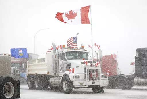 Anti-COVID-19 vaccine mandate demonstrators gather as a truck convoy blocks the highway at the busy U.S. border crossing in Coutts, Alberta, Canada, Monday, Jan. 31, 2022.  Thousands of antivaccine protesters descended on Canada’s capital of Ottawa in frigid temperatures to protest vaccine mandates, masks and restrictions over the weekend and some remain, blocking traffic around Parliament Hill in what has been the biggest pandemic protest in the country to date.(Jeff McIntosh/The Canadian Pre