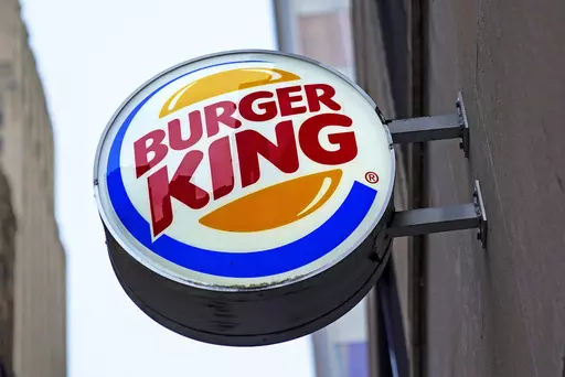 The Burger King logo is displayed on a sign outside a restaurant in downtown Pittsburgh, Jan. 12, 2022. Food ads have long made their subjects look bigger, juicier and crispier than they are in person. But some consumers say those mouthwatering ads can cross the line into deception, and that’s leading to a growing number of lawsuits. Burger King is the latest company in the crosshairs. (AP Photo/Gene J. Puskar, File)