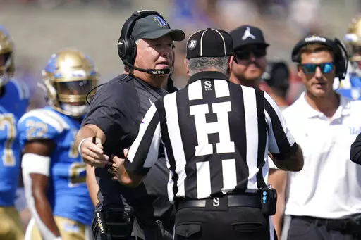 UCLA head coach Chip Kelly talks with an official during the first half of an NCAA college football game against Utah in Pasadena, Calif., Saturday, Oct. 8, 2022. (AP Photo/Ashley Landis)