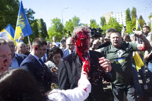 Russian Ambassador to Poland, Ambassador Sergey Andreev is covered with red paint in Warsaw, Poland, Monday, May 9, 2022. Protesters have thrown red paint on the Russian ambassador as he arrived at a cemetery in Warsaw to pay respects to Red Army soldiers who died during World War II. Ambassador Sergey Andreev arrived at the Soviet soldiers cemetery on Monday to lay flowers where a group of activists opposed to Russia’s war in Ukraine were waiting for him. (AP Photo/Maciek Luczniewski)