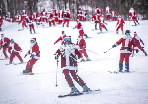 Skiers and snowboarders hit the slopes Sunday, Dec. 5, 2021 at Sunday River Ski Resort in Newry, Maine. The Santas gathered for the 21st annual Santa Sunday which raised over $4600 for the River Fund. (Andree Kehn/Sun Journal via AP)