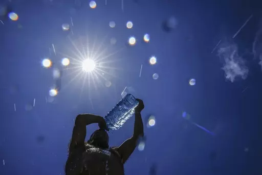 A man pours cold water onto his head to cool off on a sweltering hot day in the Mediterranean Sea in Beirut, Lebanon, July 16, 2023. European climate monitoring organization made it official: July 2023 was Earth's hottest month on record by a wide margin. (AP Photo/Hassan Ammar, File)