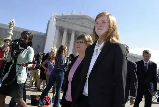 Abigail Fisher, right, who sued the University of Texas, walks outside the Supreme Court in Washington, Oct. 10, 2012. Fisher, who is white, sued after being rejected in 2008 from the University of Texas at Austin. She argued the university's policy discriminated against her because of race, in violation of the Constitution. (AP Photo/Susan Walsh, File)