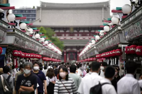 Visitors walk along a shopping street at the Asakusa District, Friday, June 10, 2022, in Tokyo. The dollar is near its highest level in more than two decades against a key index measuring six major currencies, including the euro and Japanese yen. (AP Photo/Eugene Hoshiko, File)
