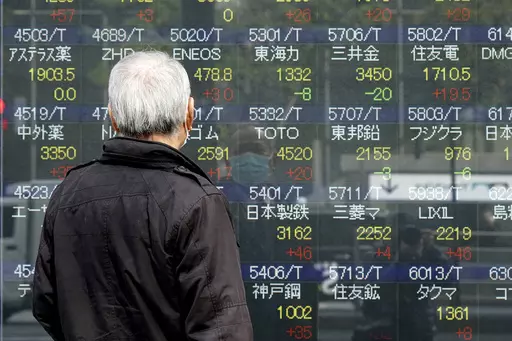 A person looks at an electronic stock board showing Japan's Nikkei 225 index at a securities firm, March 3, 2023, in Tokyo. Asian stock markets were mixed Thursday after the Federal Reserve said its economists expect a “mild recession” this year. (AP Photo/Eugene Hoshiko, File)