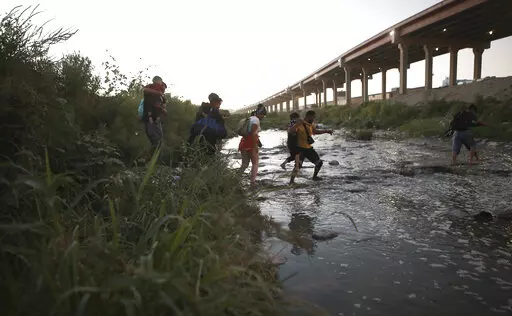 Venezuelan migrants walk across the Rio Bravo towards the United States border to surrender to the border patrol, from Ciudad Juarez, Mexico, Oct. 13, 2022. A surge in migration from Venezuela, Cuba and Nicaragua in September brought the number of illegal crossings to the highest level ever recorded in a fiscal year, according to U.S. Customs and Border Protection. (AP Photo/Christian Chavez, File)