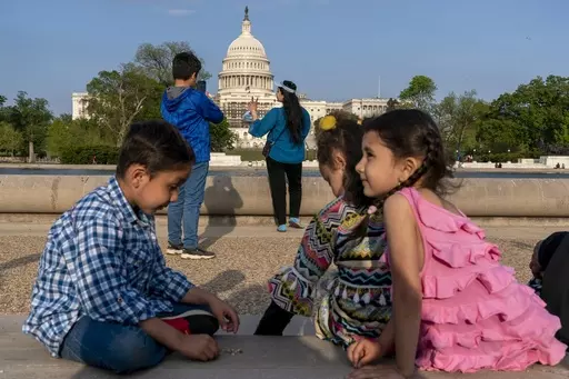 Members of the Safi family, who were evacuated from Afghanistan and are trying to make a new life in the U.S. while in immigration limbo, celebrate Eid by taking family photographs on the National Mall, May 3, 2022, near the U.S. Capitol in Washington. Growing opposition to the Senate border package once again poses a risk to the more than 76,000 Afghans who worked alongside U.S. soldiers in America’s longest war, and who are currently living in the U.S. in immigration uncertainty as a result 