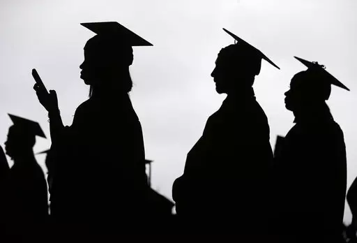 In this May 17, 2018, file photo, new graduates line up before the start of the Bergen Community College commencement at MetLife Stadium in East Rutherford, N.J.  A deadline is fast approaching for teachers, librarians, nurses and others who work in public service to apply to have their student loan debt forgiven. New figures from the U.S. Department of Education show 145,000 borrowers have had the remainder of their debt canceled through the Public Service Loan Forgiveness program. (AP Photo/Se