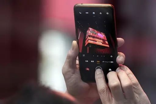 A person takes photograph an electronic stock board showing Japan's Nikkei 225 index at a securities firm Thursday, Feb. 22, 2024, in Tokyo. Japan’s benchmark Nikkei 225 index surged Thursday past the record it set in 1989 before its financial bubble burst, ushering in an era of faltering growth. (AP Photo/Eugene Hoshiko)