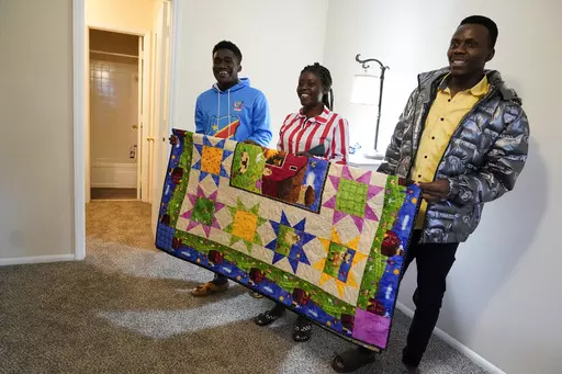 Refugees from Congo Sadock Ekyochi, from left, his wife Riziki Kashindi and her brother Kaaskile Kashindi pose for a photo inside their new apartment, Thursday, April 11, 2024, in Columbia, S.C. The American refugee program, which long served as a haven for people fleeing violence around the world, is rebounding from years of dwindling arrivals under former President Donald Trump. The Biden administration has worked to restaff refugee resettlement agencies and streamline the process of vetting a