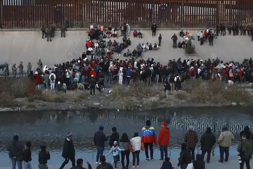 Migrants gather at a crossing into El Paso, Texas, as seen from Ciudad Juarez, Mexico, Tuesday, Dec. 20, 2022. Tensions remained high at the U.S-Mexico border Tuesday amid uncertainty over the future of restrictions on asylum-seekers, with the Biden administration asking the Supreme Court not to lift the limits before Christmas. (AP Photo/Christian Chavez)