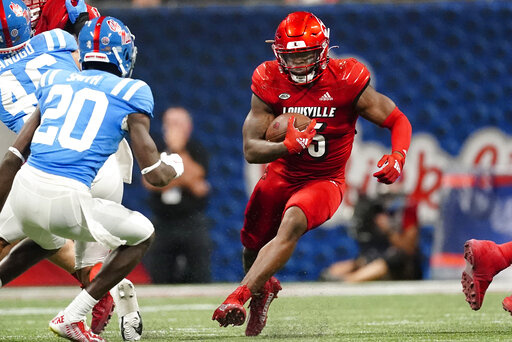 Louisville running back Jalen Mitchell (15) runs up the middle as Mississippi defensive back Keidron Smith (20) moves in during the second half of an NCAA college football game Monday, Sept. 6, 2021, in Atlanta. (AP Photo/John Bazemore)