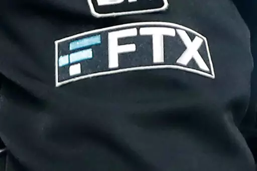 The FTX logo appears on home plate umpire Jansen Visconti's jacket at a baseball game with the Minnesota Twins on Sept. 27, 2022, in Minneapolis. The FTX bankruptcy filing followed a bruising of crypto companies throughout 2022, due in part to rising interest rates and the broader market downturn that has many investors rethinking their lust for risk. (AP Photo/Bruce Kluckhohn, File)