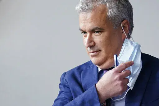 White House COVID-19 Response Coordinator Jeff Zients removes a face mask as he prepares to speak at a press briefing at the White House in Washington, April 13, 2021. The White House said Wednesday, Feb. 9, 2022, that it was beginning to prepare for the next phase of the pandemic response amid growing impatience for the federal government to ease up. Zients said officials have started consultations in recent weeks with state and local leaders and public health officials “on steps we should be
