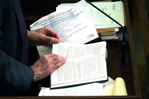 State Rep. Tommy Reynolds, D-Charleston, refers to a section of Mississippi Code, Tuesday, Feb. 21, 2023, as he speaks on a bill at the Mississippi Capitol in Jackson, Miss.. Lawmakers are working towards a Wednesday deadline for original floor action on appropriations and revenue bills originating in their own House. (AP Photo/Rogelio V. Solis)