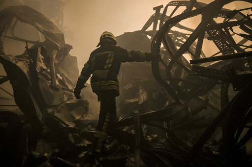 A Ukrainian firefighter walks inside a large food products storage facility which was destroyed by an airstrike in the early morning hours on the outskirts of Kyiv, Ukraine, Sunday, March 13, 2022. Waves of Russian missiles pounded a military training base close to Ukraine's western border with NATO member Poland, killing 35 people, following Russian threats to target foreign weapon shipments that are helping Ukrainian fighters defend their country against Russia's grinding invasion.(AP Photo/Va