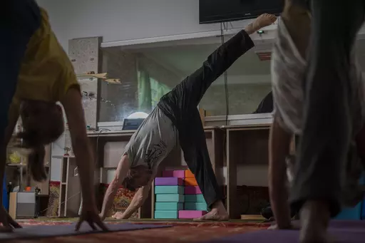 Serhii Zaloznyi, center, a 52-year-old yoga instructor, holds a yoga session in a basement in Kramatorsk, Donetsk region, Ukraine, Thursday, Sept. 14, 2023. In a basement in one of the front-line cities in the Donetsk region, people gather three times a week in the morning for yoga to alleviate the stress caused by Russia’s constant shelling. (AP Photo/Hanna Arhirova)