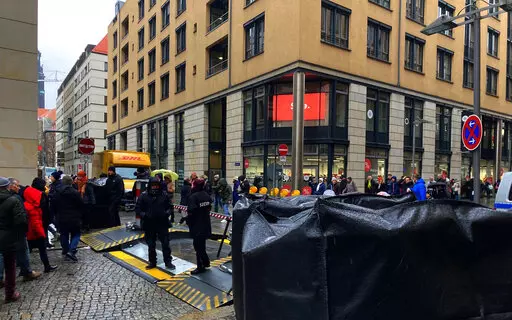People gather near the Altmarktgalerie after a hostage situation in Dresden, Germany, Saturday Dec. 10, 2022. German police say they have ended a hostage situation in the eastern city of Dresden after there were reports of shots fired. Police had urged people to avoid an area in the city center on Saturday morning while the operation was underway. (Jorg Schurig/dpa via AP)