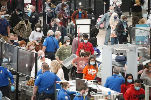 Travelers queue up at the south security checkpoint as traffic increases with the approach of the Thanksgiving Day holiday Tuesday, Nov. 23, 2021, at Denver International Airport in Denver. (AP Photo/David Zalubowski)