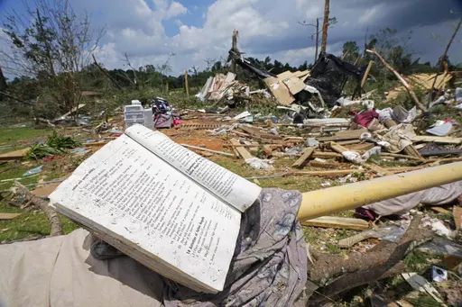 A prayer book rests on a parking barrier, June 19, 2023, among the debris from an apparent tornado that swept through Louin, Miss., the night before. Mississippi Gov. Tate Reeves has requested financial assistance from the federal government for 16 counties impacted by tornadoes and damaging storms that swept across the state over a five-day period in June, he announced Monday, July 24. (AP Photo/Rogelio V. Solis, File)