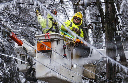Crews work to restore power to the Central Garden neighborhood of Memphis, Tenn., on Friday, Feb. 4, 2022. More than 120,000 customers were without power Friday afternoon in Shelby County, according to poweroutage.us, which tracks utility reports.  (Patrick Lantrip/Daily Memphian via AP)