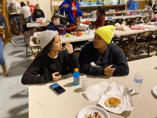 Courtney Saxton chats with her 13-year-old daughter, Querria, at the St. Jerome Parish Hall in Fancy Farm, Ky., on Saturday, Dec. 11, 2021. The family’s Mayfield, Ky., home was destroyed by a tornado. (AP Photo/Bruce Schreiner)