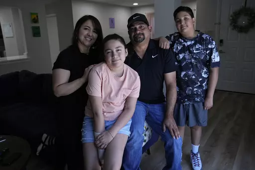 Mayah Zamora, second from left, a survivor of the mass shooting at Robb Elementary in Uvalde, Texas, poses for a photo with her mom Christina, left, dad Ruben, and brother Zach, right, at their home in San Antonio, Tuesday, June 27, 2023. Besides medical bills and the weight of trauma and grief, mass shooting survivors and their family members contend with scores of other changes that show how thoroughly their lives have been upended by violence. (AP Photo/Eric Gay)