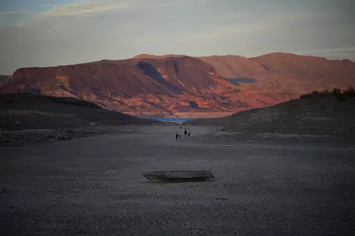 A formally sunken boat sits on cracked earth hundreds of feet from what is now the shoreline on Lake Mead at the Lake Mead National Recreation Area, Monday, May 9, 2022, near Boulder City, Nev. Lake Mead is receding and Sin City is awash with mob lore after a second set of human remains emerged within a week from the depths of the drought-stricken Colorado River reservoir just a short drive from the Las Vegas Strip.  (AP Photo/John Locher)