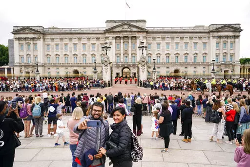 Members of the public watch the Changing of the Guard ceremony at Buckingham Palace, London, Monday August 23, 2021, which is taking place for the first time since the start of the coronavirus pandemic. (AP Photo/Alberto Pezzali)