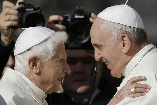 Pope Francis, right, hugs Emeritus Pope Benedict XVI prior to the start of a meeting with elderly faithful in St. Peter's Square at the Vatican on Sept. 28, 2014. (AP Photo/Gregorio Borgia, File)