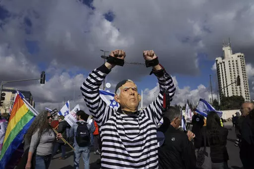 A protester wearing a rubber mask depicting Israeli Prime Minister Benjamin Netanyahu demonstrates in front of the Supreme Court in Jerusalem against the appointment of Aryeh Deri, the leader of the ultra-Orthodox Shas party as the country's new health minister, Thursday, Jan, 5, 2023. (AP Photo/Mahmoud Illean, File)