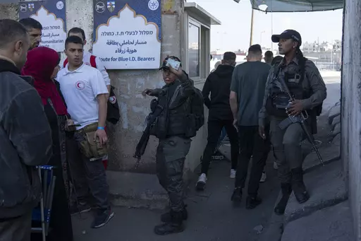 Israeli border police officers check identification cards of Palestinians while they try to cross from the occupied West Bank into Jerusalem, to pray during the holiest night of Ramadan, Laylat al-Qadr, or the "Night of Destiny," when Muslims believe that the Quran was revealed to the Prophet Mohammad, in the Al Aqsa mosque compound, at the Israeli military Qalandiya checkpoint, near Ramallah, Monday, April 17, 2023. Hundreds of thousands of Palestinians are barred from legally crossing into the