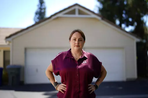 Kate Needham, a veteran who co-founded the nonprofit Armed Forces Housing Advocates, looks on in a housing complex, Tuesday, Aug. 16, 2022, in San Diego. Needham's group supplies microgrants to military families in need, some of whom have resorted to food banks because their salaries do not cover such basics. “I don’t think civilians really understand — they might think we’re living in free housing and just having a great time, making lots of money. And that’s not the case at all.” (